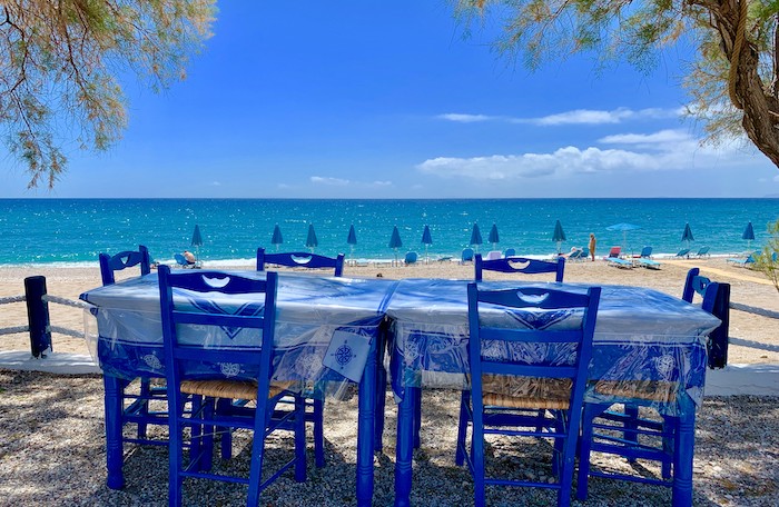 Blauwe Griekse stoeltjes aan zee in Votsalakia op Samos